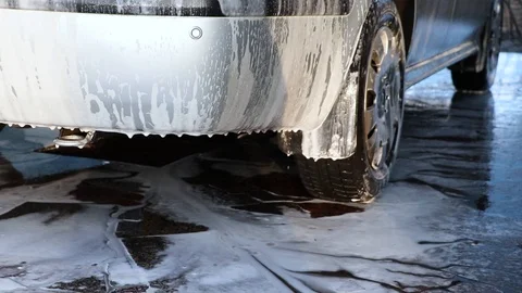 Large droplets of foam run off the gray machine to clean the machine of dirt. Ma Stock-Footage 124125561