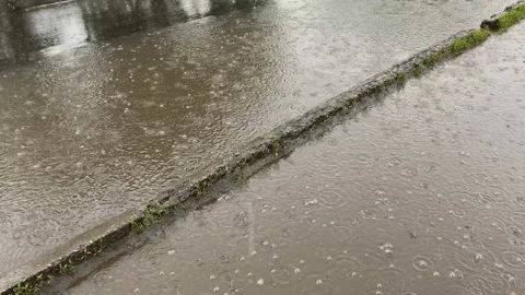 Large drops of rainwater fall on the asphalt, pavement, in a puddle.rainy season Stock Footage 156179675