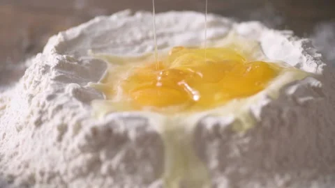 Large egg splashing into pool of three eggs and flour shot in slow motion 12 Stock Footage 171484762