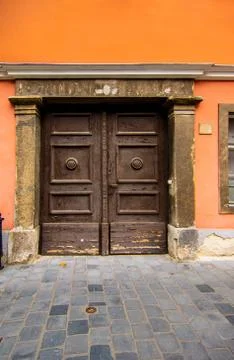 Large elegant brown door in a building with orange walls. Historical heritage in Stock Photos