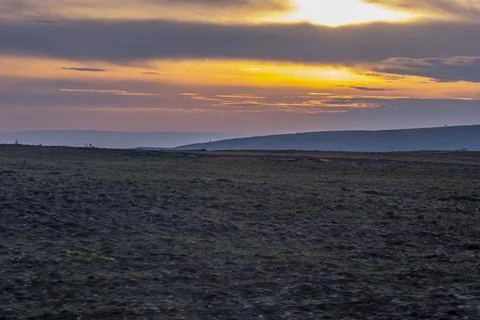 A large, empty field with a beautiful sunset in the background 스톡 사진