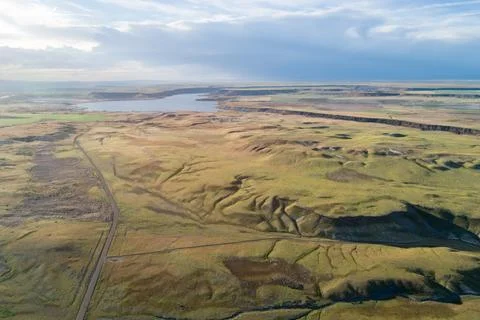 A large, empty field with a road running through it Stock Photos
