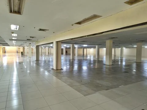 Large empty indoor commercial space with pillars and tiled floor. Fotos Stock