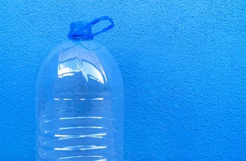 Large empty plastic bottle isolated on a blue background close-up. Foto stock