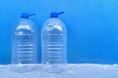 Large empty plastic bottle isolated on a blue background close-up. Stock Photos