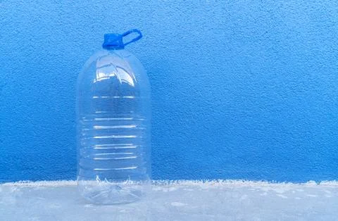 Large empty plastic bottle isolated on a blue background close-up. Stock Photos