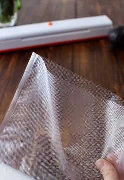 A large empty ribbed vacuum bag in hand for packing at home Stock Photos