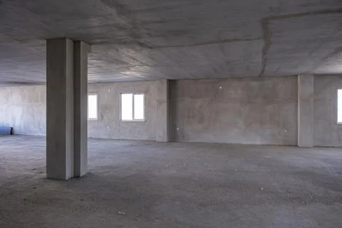 A large empty room with a cement ceiling and a concrete pillar Fotos Stock