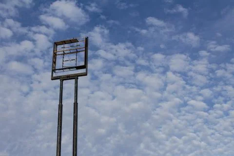 Large empty sign frame against a blue sky with clouds, copy space Stock Photos