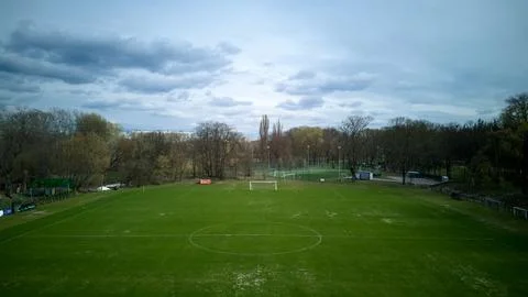 Large, empty soccer field with a cloudy sky in the background Stock Photos