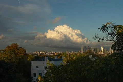 Large evening puffy clouds over Canary Wharf London 库存照片