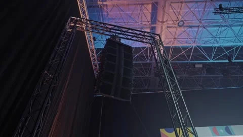 Large event hall speaker array suspended from industrial truss structure Stock Footage 323420498