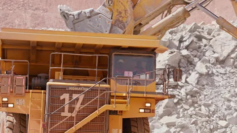 Large excavator depositing rubble onto the back of a heavy duty dump truck Stock Footage 241214456