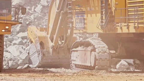 Large excavator depositing rubble onto the back of a heavy duty dump truck Stock Footage 241214930