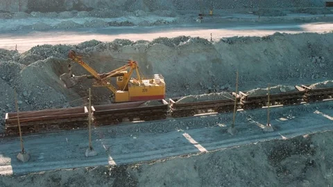 Large excavator loading rock formation it to the freight train. Gold mining. Stock Footage 164403530