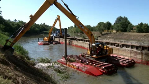 Large excavators engaged in cleaning of the riverbed of a river from the mud Video stock 137208153