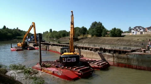 Large excavators engaged in cleaning of the riverbed of a river from the mud Video stock 137210240