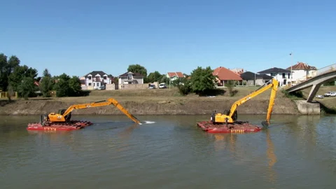 Large excavators on pontoons engaged in cleaning of the riverbed of a river Stock Footage 137059980