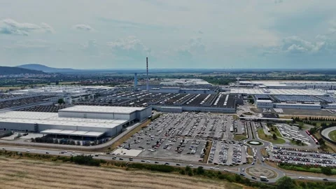Large factory complex with parking lot and mountains in background Stock Footage 340382364
