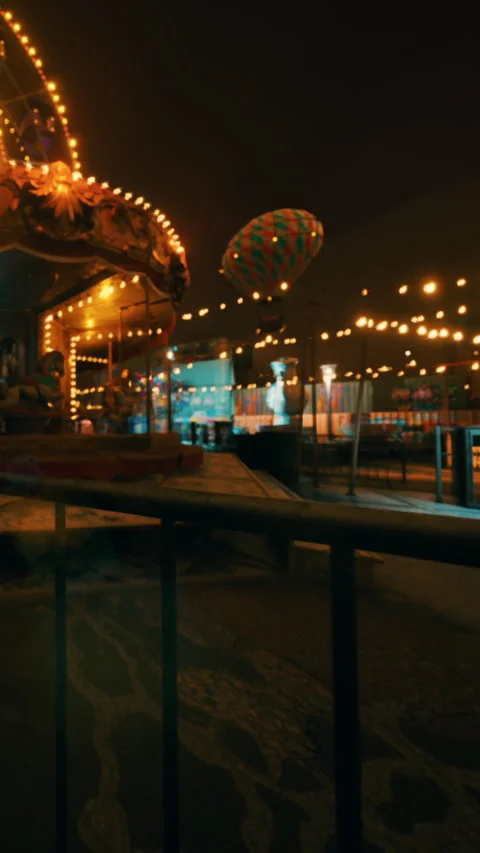Large fair with rides and lights at night with a hot air balloon in view Stock Footage 342103155