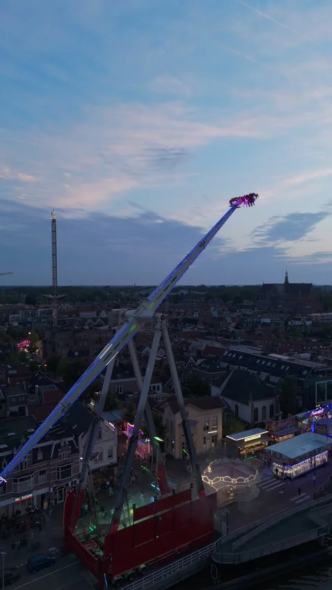 Large fairground thrill ride swinging high at dusk 動画素材 345255527