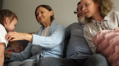 Large family of five cuddling while sitting on a sofa. Grandfather and Stock Footage 121445760