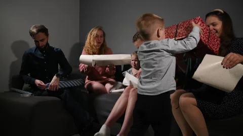 Large family happily wrapping multiple gifts in colorful paper 스톡 동영상 340065991