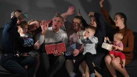 Large family happily wrapping multiple gifts in colorful paper Vídeos de archivo 340066960