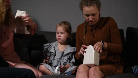 Large family happily wrapping multiple gifts in colorful paper together Video stock 340068425