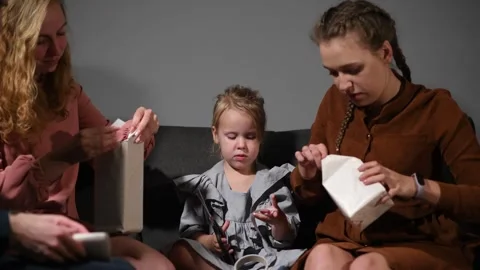 Large family happily wrapping multiple gifts in colorful paper together 스톡 동영상 340068600