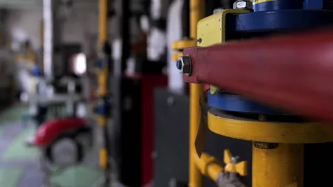 A large faucet valve on a large pipe of an industrial boiler house or factory. Stock Footage 231803143