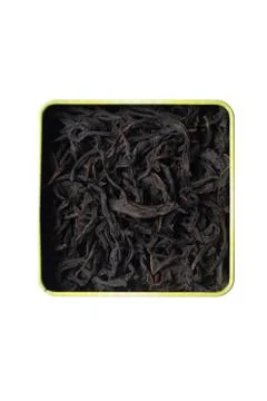 Large fermented willow-tea leaves in a square tin can. Isolate on a white bac Stock Photos