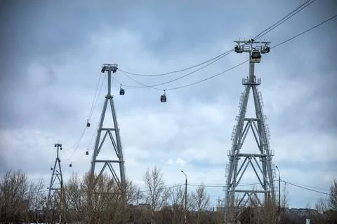 A large ferris wheel is being pulled by a cable car system Stock Photos
