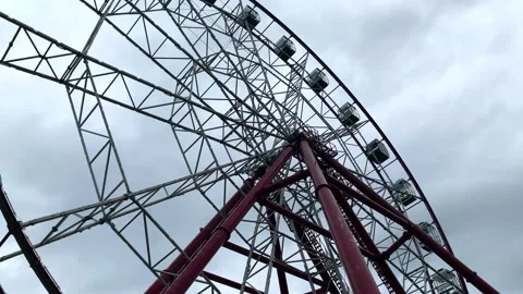 Large Ferris wheel close-up against a gray cloudy sky Stock Footage 145074016