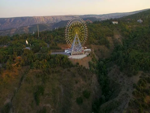 Large ferris wheel on  mountain at sunset. video editing aerial view 스톡 동영상 80300409