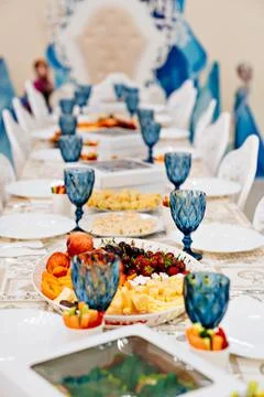 A large festive table with appetizers and glasses of blue glass. Foto stock
