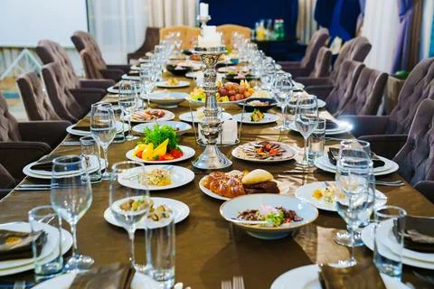 A large festive table with candles, snacks and tableware. Stock Photos