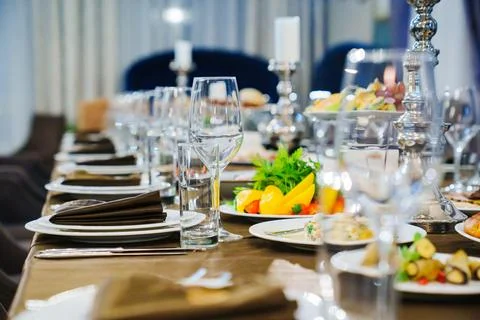 A large festive table with candles, snacks and tableware. Stock Photos