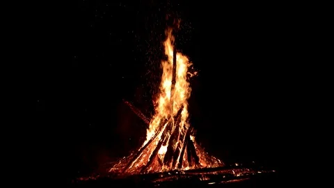 Large fire burning at night with smoke and sparks rising on a dark background Stock Footage 88225376