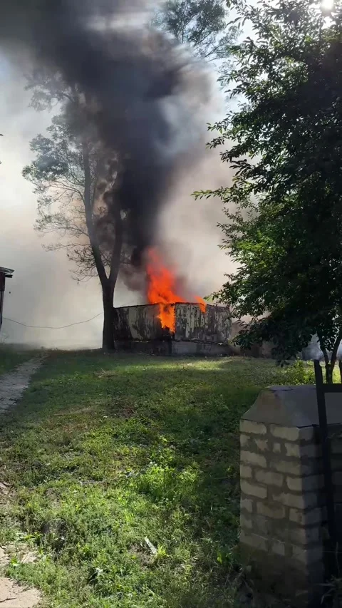 Large Fire with Red Flames and Thick Black Smoke Rising Above a Building Stock Footage 346517912