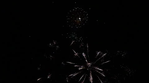 Large firework with smaller fireworks beneath and left side copy space Video stock 235221232