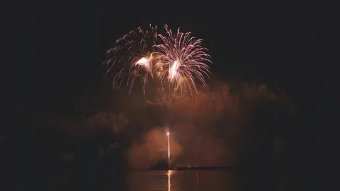 Large fireworks exploding high into night sky spreading golden sparks Stock Footage 340744836