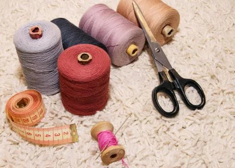 Large five spools of thread, a meter, a spool of pink thread with a needle an Stock Photos