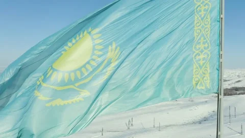 Large flag of Kazakhstan fluttering in wind against the background of mountains  스톡 동영상 233361762