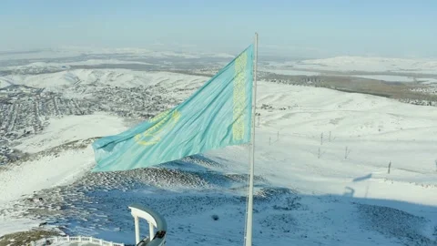 Large flag of Kazakhstan fluttering in wind against the background of mountains  스톡 동영상 233363632
