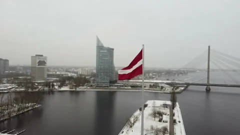 Large flag of Latvia in front of modern office buildings Stock Footage 147031951