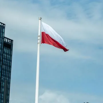 Large flag of Poland fluttering in the wind on a high mast Фото