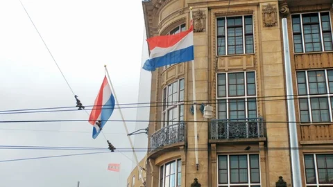 Large flags of the Netherlands on the flagpoles of old houses in Amsterdam Stock-Footage 119099040