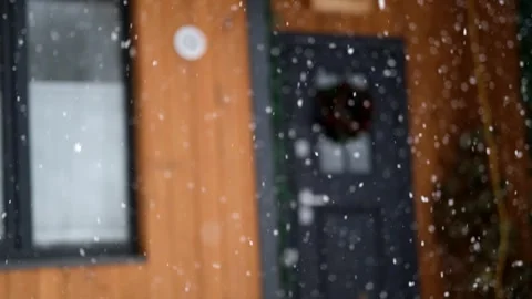 Large flakes of snow fall against the background of a country house door 스톡 동영상 303717817