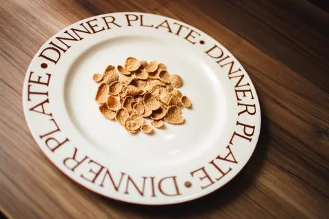 Large flat plate with crispy corn flakes closeup. Wooden background Stock Photos